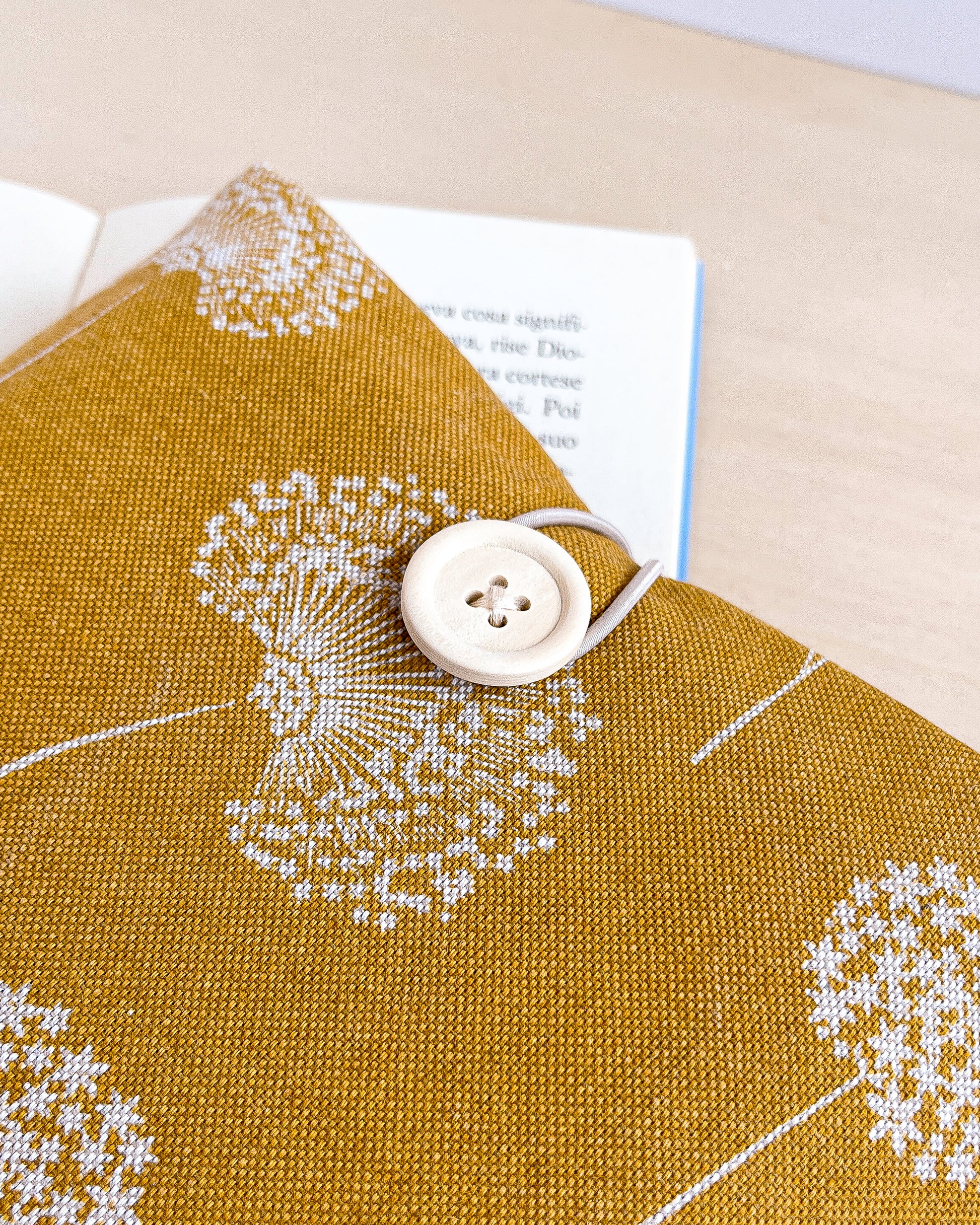 Custodia per libri imbottita in cotone fantasia ocra con fiori bianchi fatta a mano